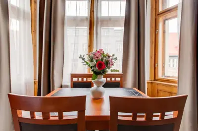 a dining room table with a vase of flowers on it at Kafka Prague rooms in Prague