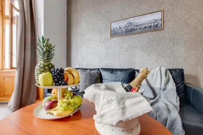 a table with a bowl of fruit on it at Kafka Prague rooms in Prague