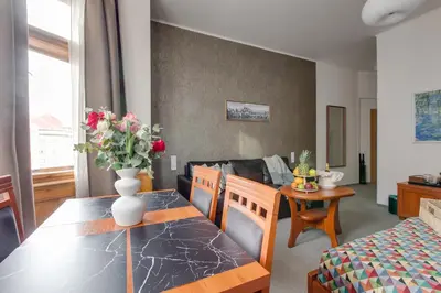 a living room with a table with a vase of flowers at Kafka Prague rooms in Prague