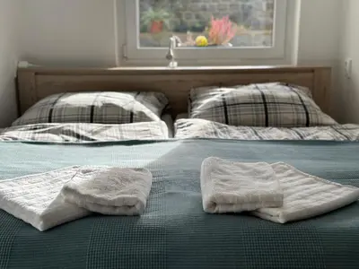 two towels sitting on a bed with a sink at Byt v rezidenční čtvrti Prahy 6 in Prague