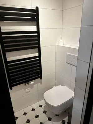 a bathroom with a toilet and a tiled floor at Byt v rezidenční čtvrti Prahy 6 in Prague