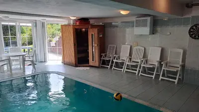 a house with a swimming pool and chairs and a table at Wellness Villa Vranov 55 in Čerčany