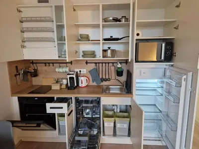 a kitchen with white cabinets and a refrigerator at Prague City Center Apartment in Prague