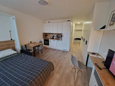 a bedroom with a bed and a desk and a kitchen at Prague City Center Apartment in Prague