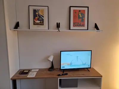 a television sitting on a desk with two shelves at Prague City Center Apartment in Prague