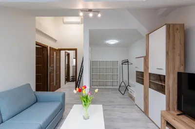 a living room with a blue couch and a tv at Apartment Cimburkova in Prague
