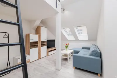 a living room with a blue couch and a tv at Apartment Cimburkova in Prague