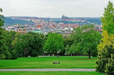 a group of people sitting in a field in a park at Apartment Cimburkova in Prague