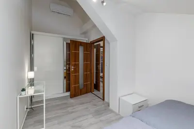 a white bedroom with a bed and a mirror at Apartment Cimburkova in Prague