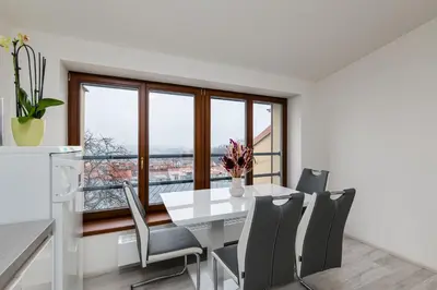 a dining room with a white table and chairs at Apartment Cimburkova in Prague