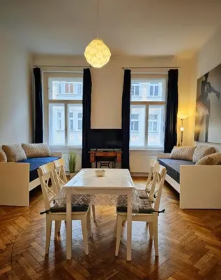 a living room with a table and chairs and a couch at Slezska Apartments in Prague