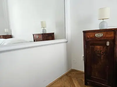 a bedroom with a mirror and a wooden dresser at Slezska Apartments in Prague