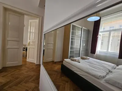 a bedroom with a large mirror on the wall at Slezska Apartments in Prague