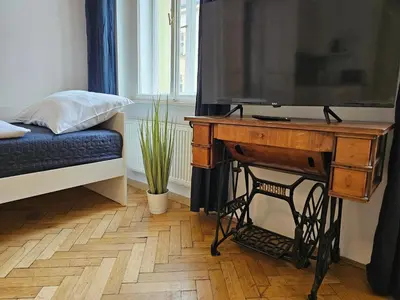 a room with a tv and a table with a desk at Slezska Apartments in Prague