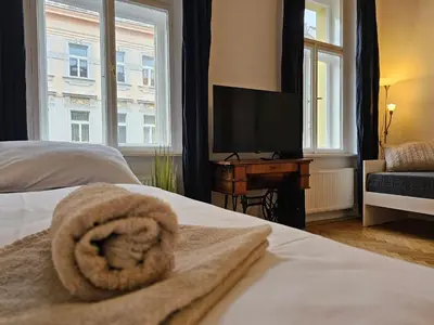 a bedroom with a bed with a towel on it at Slezska Apartments in Prague