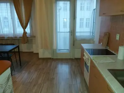 a kitchen with wooden floors and windows and a table at Apartments Tronicek in Prague