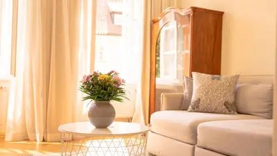 a living room with a couch and a vase with flowers on a table at Residence Dvorak in Prague
