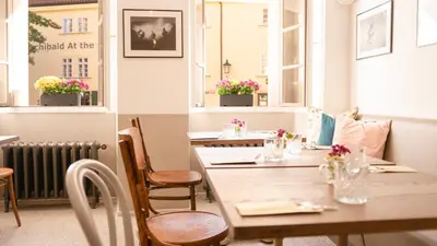 a dining room with tables and chairs and windows at Residence Dvorak in Prague