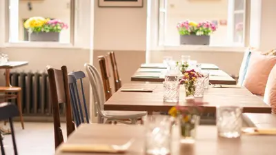 a row of tables in a restaurant with flowers at Residence Dvorak in Prague