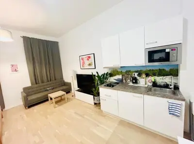 a kitchen with white cabinets and a couch in a room at NEW DESIGN & STYLE Apartments 50m from Wenceslas Square in Prague