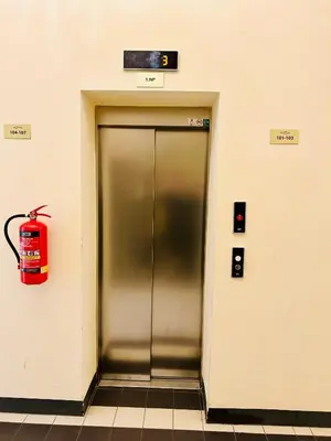 a metal elevator with a fire extinguisher on a wall at NEW DESIGN & STYLE Apartments 50m from Wenceslas Square in Prague