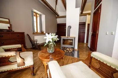 a living room with a table and a fireplace at Dvůr Pecínov in Benešov