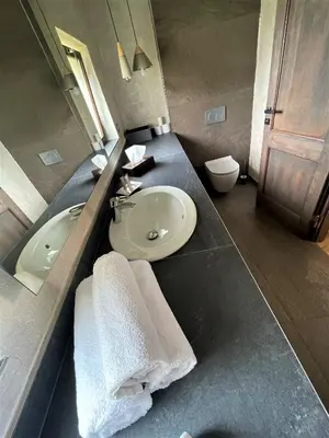 a bathroom with a sink and a toilet and a mirror at Dvůr Pecínov in Benešov