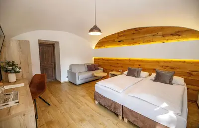 a bedroom with a large white bed and a chair at Dvůr Pecínov in Benešov