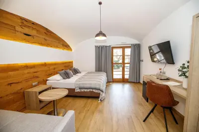 a bedroom with a bed and a desk and a tv at Dvůr Pecínov in Benešov