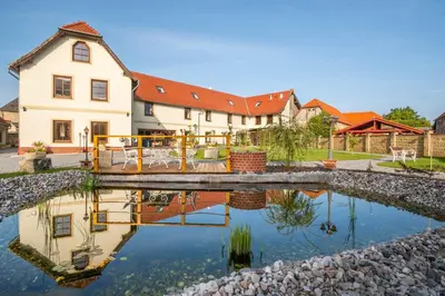 a house with a pond in front of it at Kokořín Apartments in Kokořín