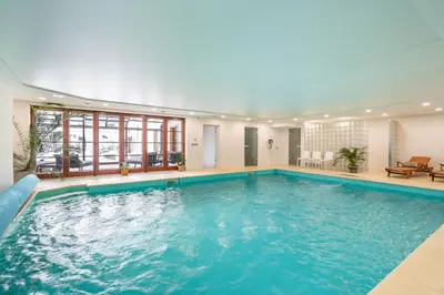 a large swimming pool in a building with a large swimming pool at Kokořín Apartments in Kokořín