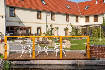 a bench on a wooden deck in front of a building at Kokořín Apartments in Kokořín