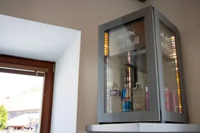 a glass cabinet with bottles in it on a wall at Kokořín Apartments in Kokořín