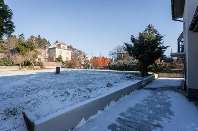 a yard covered in snow with a fence at Apartmán Praha in Prague
