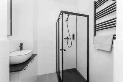 a bathroom with a glass shower and a sink at Apartmán Praha in Prague
