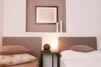 a bedroom with two beds and a picture on the wall at Villa na Vinici in Prague