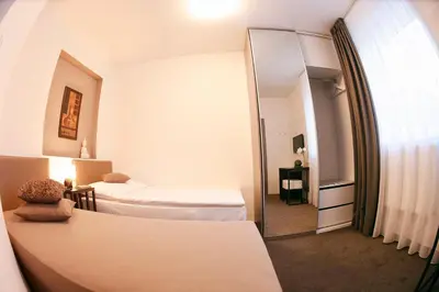 a hotel room with two beds and a mirror at Villa na Vinici in Prague