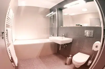 a bathroom with a sink and a tub and a toilet at Villa na Vinici in Prague