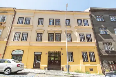 a yellow building with a car parked in front of it at Nice room with double bed in zizkov - shared bathroom in Prague