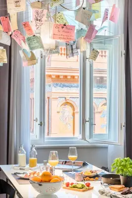 a table with two glasses of wine and a window at MOOo Downtown in Prague