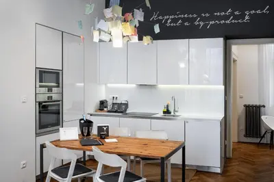 a kitchen with a wooden table and white cabinets at MOOo Downtown in Prague