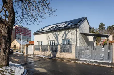 a white building with a solar roof on a street at Apartmány Praha-Modřany in Prague