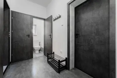 a black and white bathroom with a toilet and a door at Apartmány Praha-Modřany in Prague