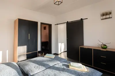 a bedroom with a bed and a dresser at Apartmány Praha-Modřany in Prague