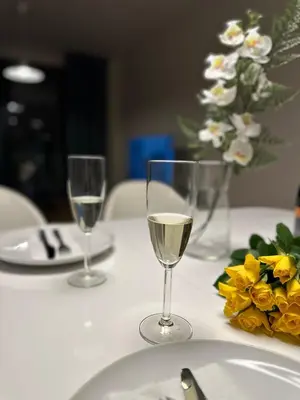 two glasses of white wine on a table with flowers at Apartment 4 Room, 2 Bath, Parking in Prague