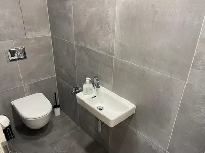 a bathroom with a white sink and a toilet at Apartment 4 Room, 2 Bath, Parking in Prague