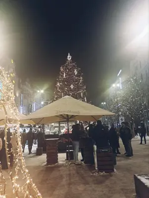 a group of people standing around a market with a christmas tree at Apartment Prague city center - next to Florenc in Prague