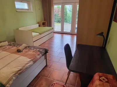 a room with two beds and a chair in it at Ubytování na kopečku in Beroun
