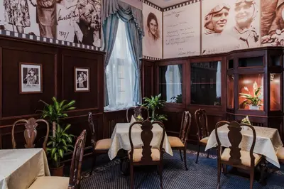 a dining room with tables and chairs and pictures on the walls at Palace Inn in Jíloviště