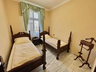 two beds in a room with a window at Palace Inn in Jíloviště